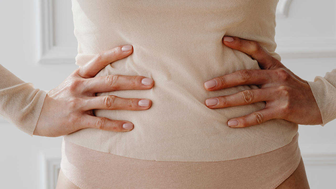 donna si tiene il ventre con le mani